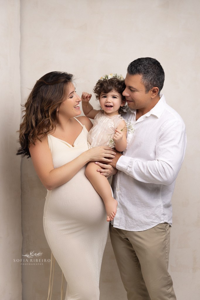 mom dad and big sister get ready for a pose against moms pregnant belly during a maternity session in re bank nj