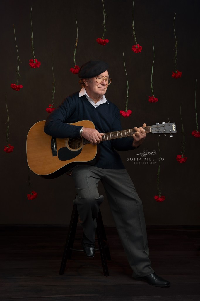 man posing as jose afonso inspiration with a carnation in the air to celebrate 25 de abril 50th anniversary. Modelo a fazer de jose afonso, com cravo na mao em homenagem ao cinquentenario de 25 de abril, portugal's carnation revolution