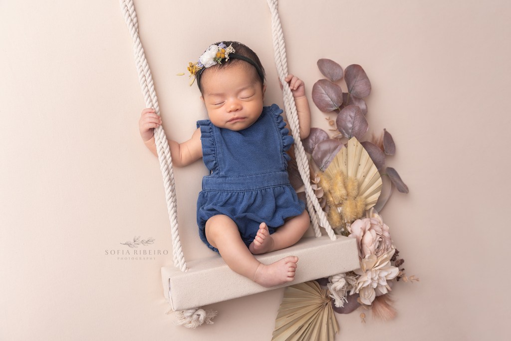 newborn baby girl on a swing prop for a newborn session in englewood nj