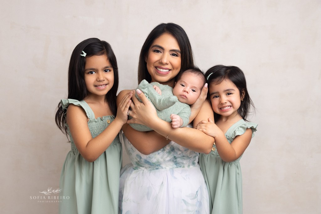 mom holds baby boy surrounded by her daughters