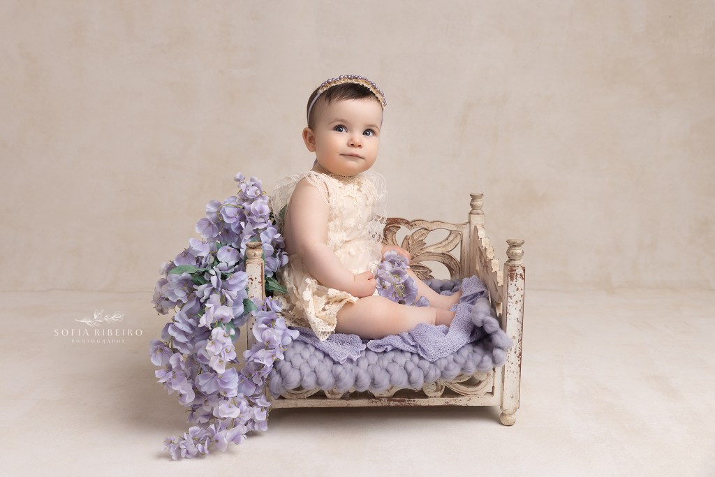 baby sits in a bed prop during a session witha westfield nj baby photographer