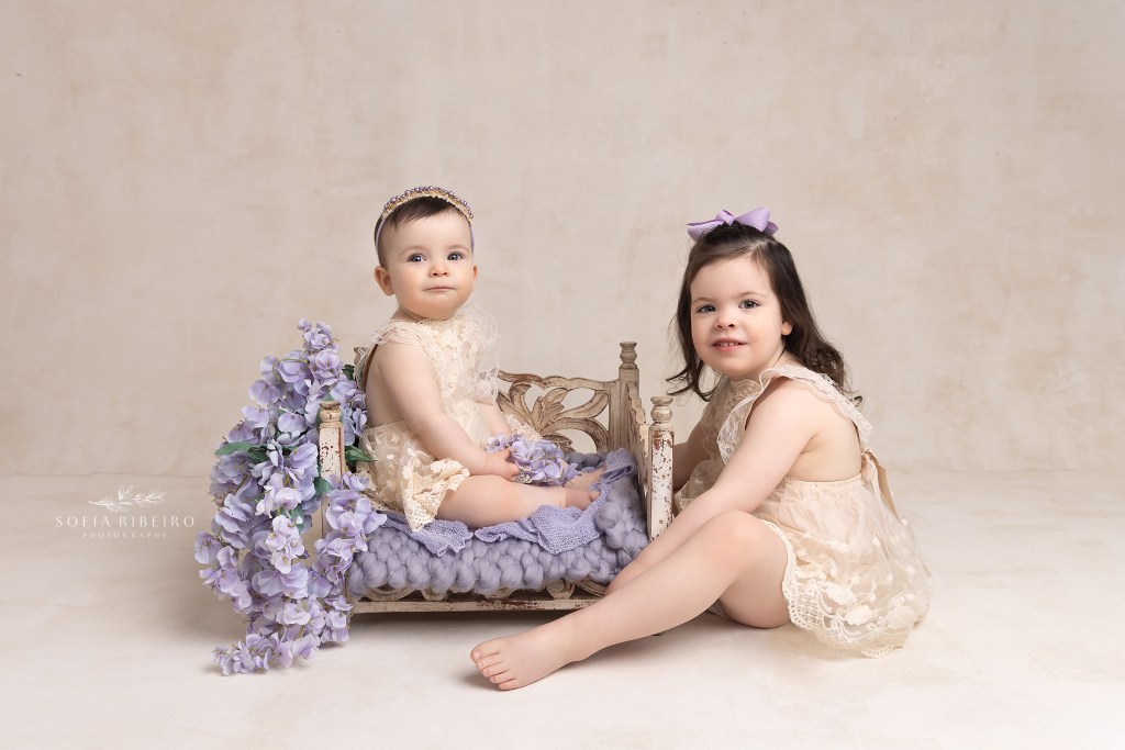 sisters share a moment during a session in westfield nj with a baby photographer