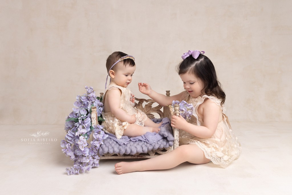 sisters share a moment during a session in westfield nj with a baby photographer