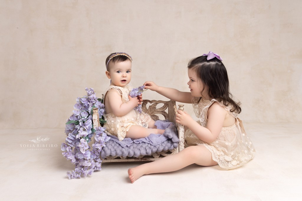 sisters share a moment during a session in westfield nj with a baby photographer