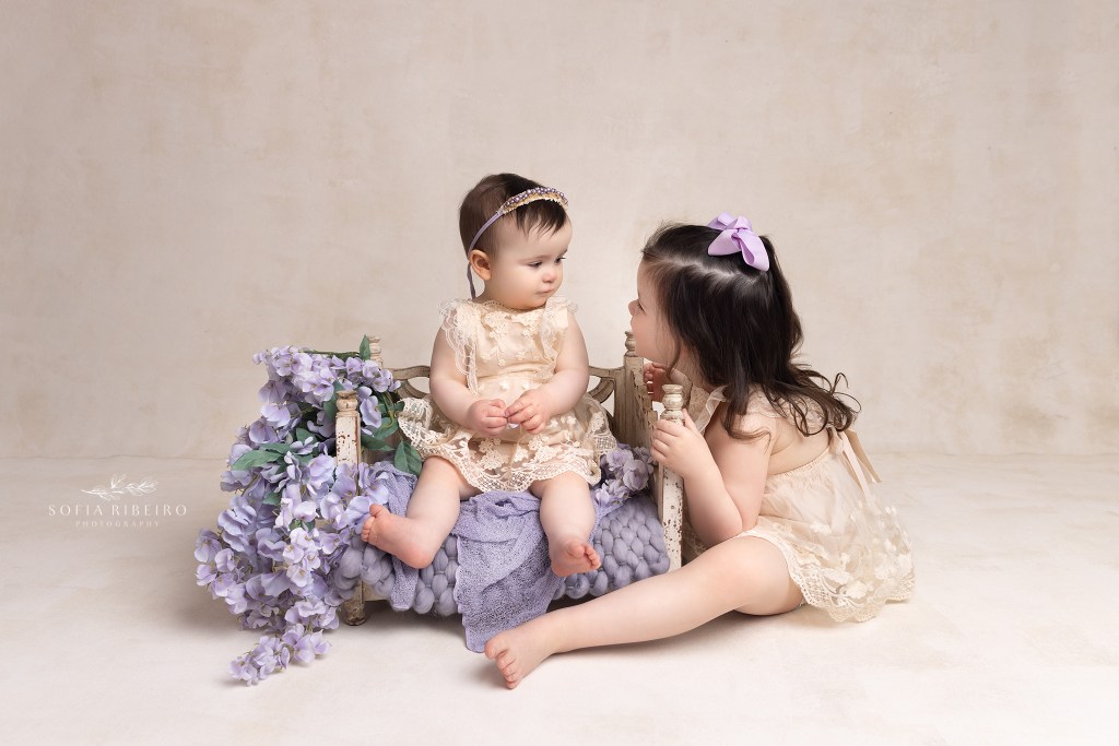 sisters share a moment during a session in westfield nj with a baby photographer