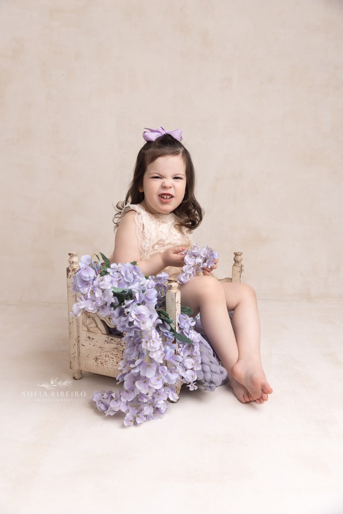 baby sits in a bed prop during a session witha westfield nj baby photographer