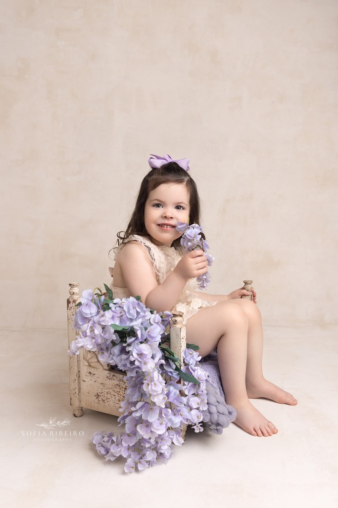 baby sits in a bed prop during a session witha westfield nj baby photographer