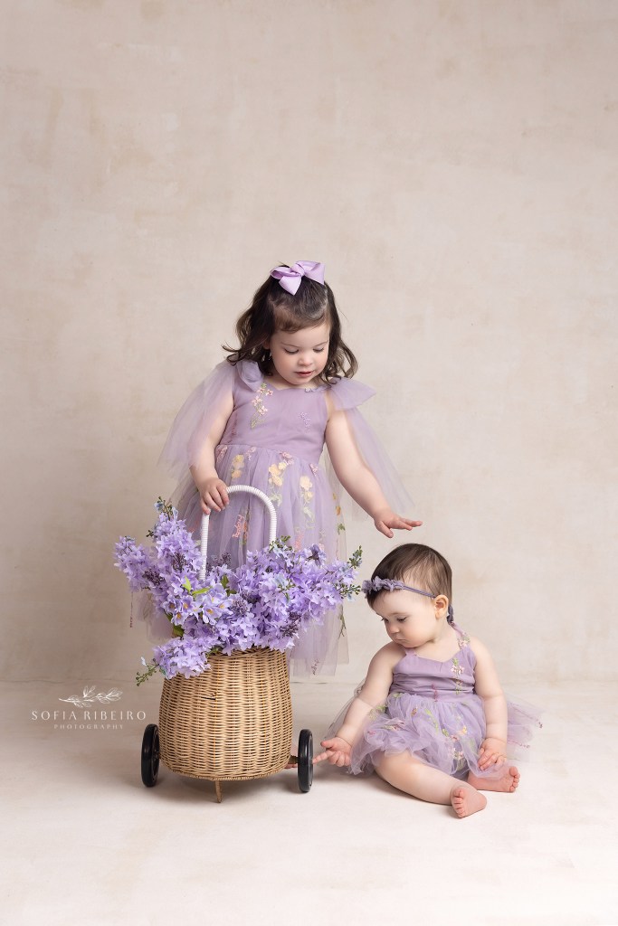 big sister giggles with baby sister during a photo session in westfield nj