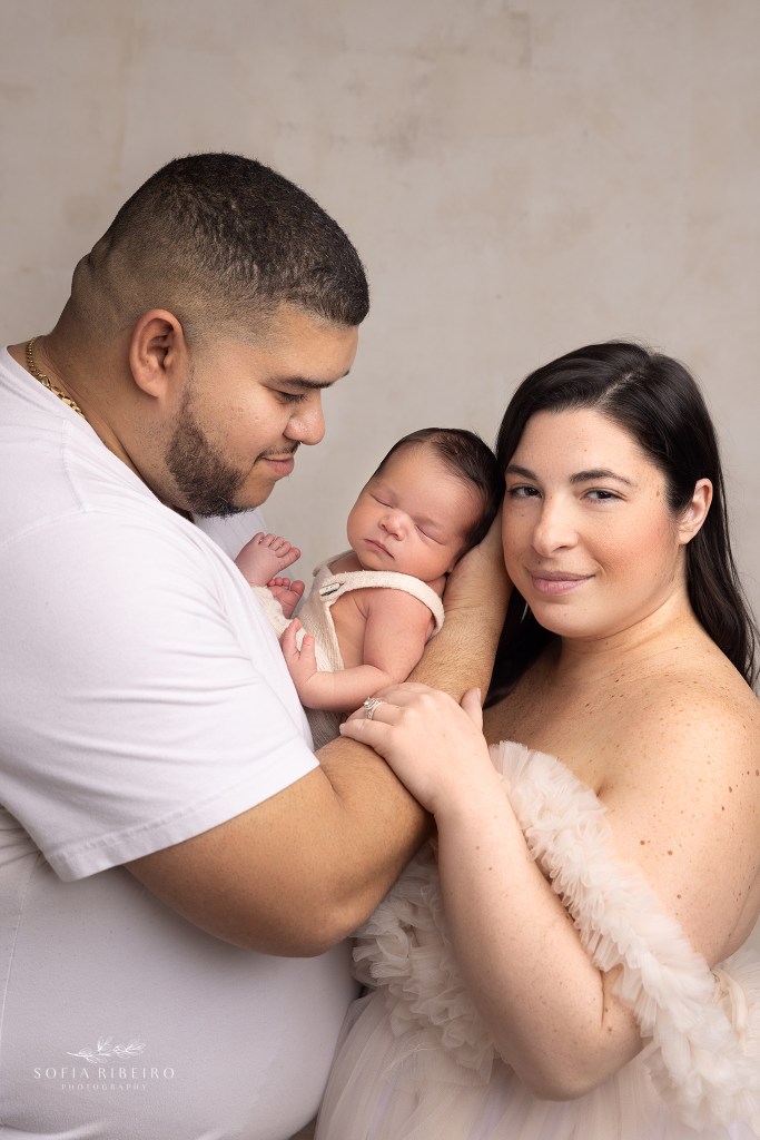 mom and dad take a portrait together with their newest addition