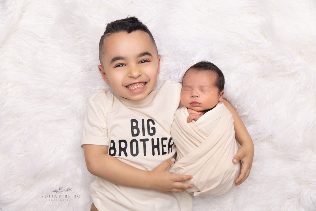 big brother wears a big brother tee while holding his new baby brother