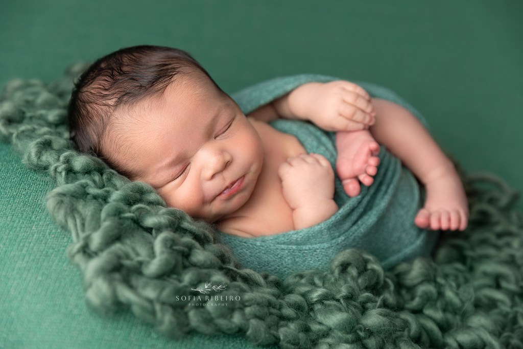 baby is wrapped in gorgeous greens and sleeps softly during newborn photos in wharton nj