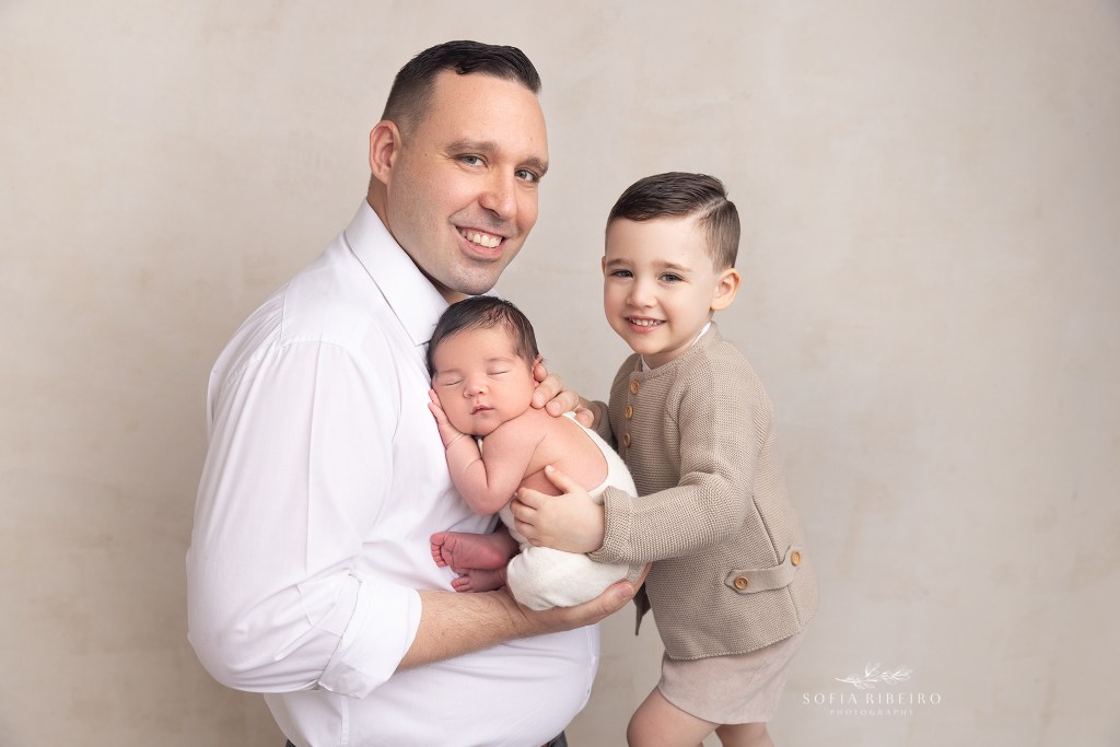 dad smiles while holding his babies during a photo session in clark nj