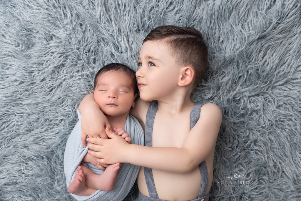 baby brother kisses his new little brother during a newborn photo session in clark nj