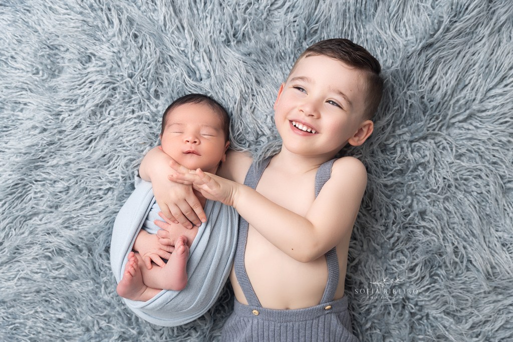 big brother hugs his newborn baby brother during a photo session in clark nj