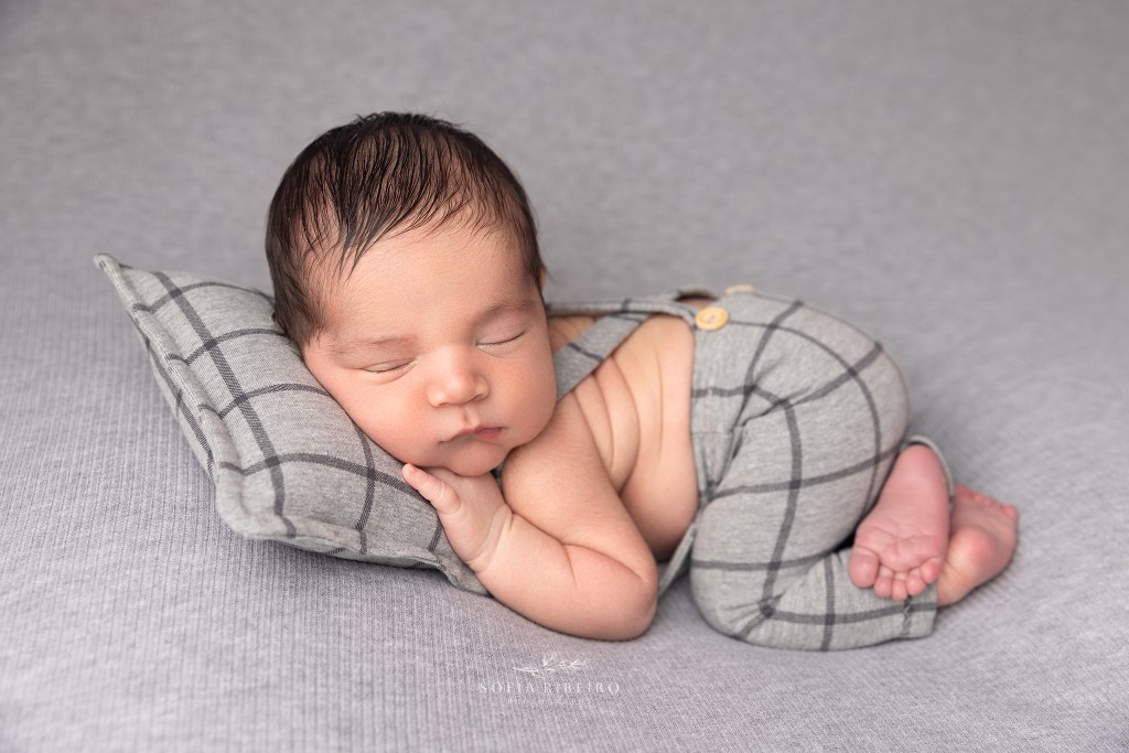 baby sleeps soundly on a grey pillow during a newborn session in clar nj
