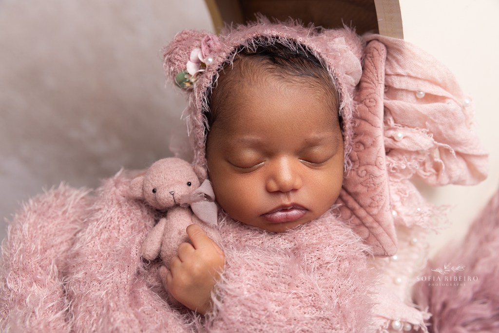 newborn baby girl poses with a stuffed bear during a photo session in bloomfield nj