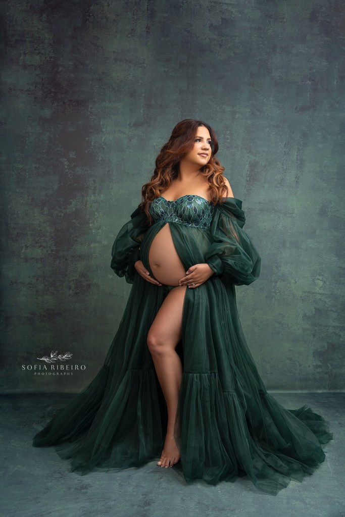 mom to be dazzles in an emerald green gown while posing for a maternity photographer in neptune nj
