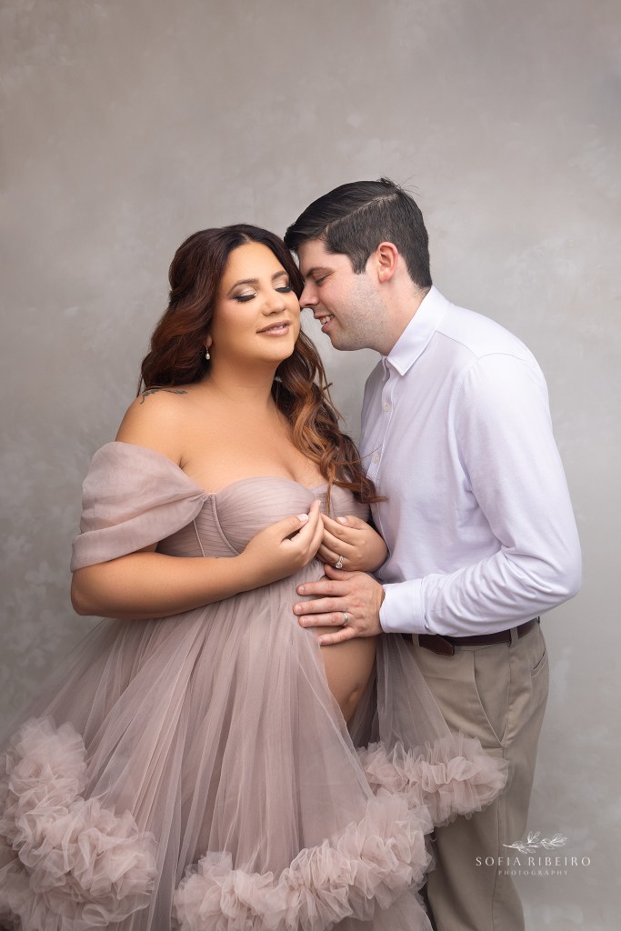 mom and dad share a snuggle during their maternity session