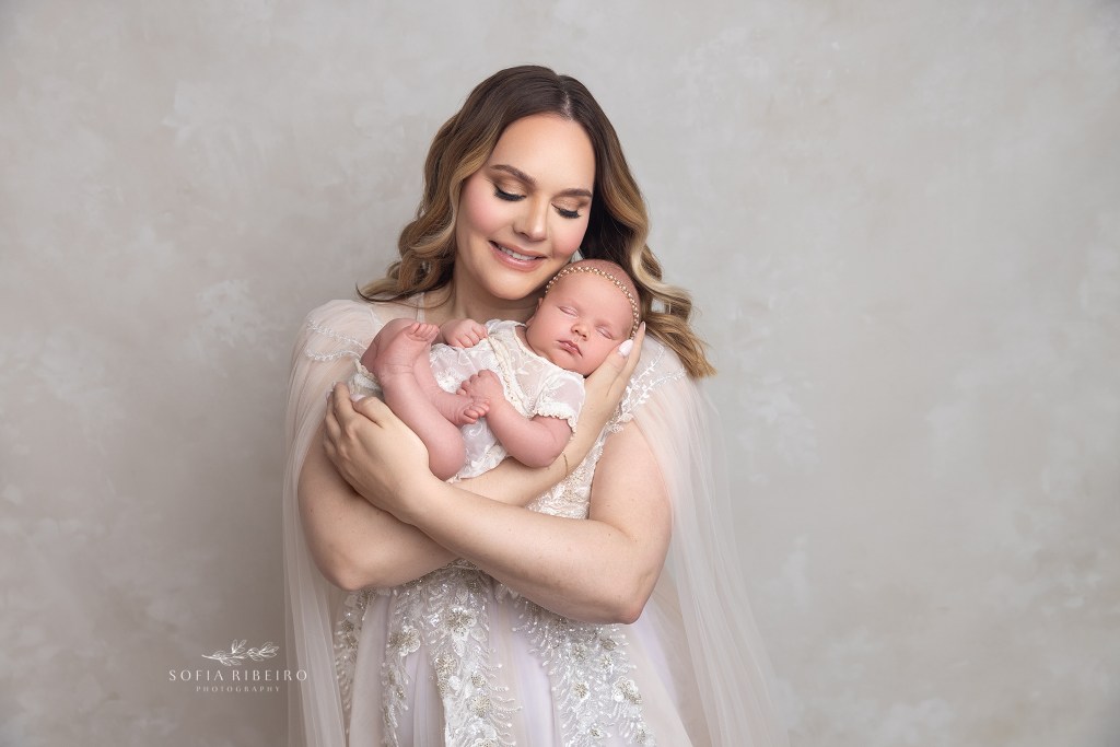 mom holds her baby girl during a newborn session in nj