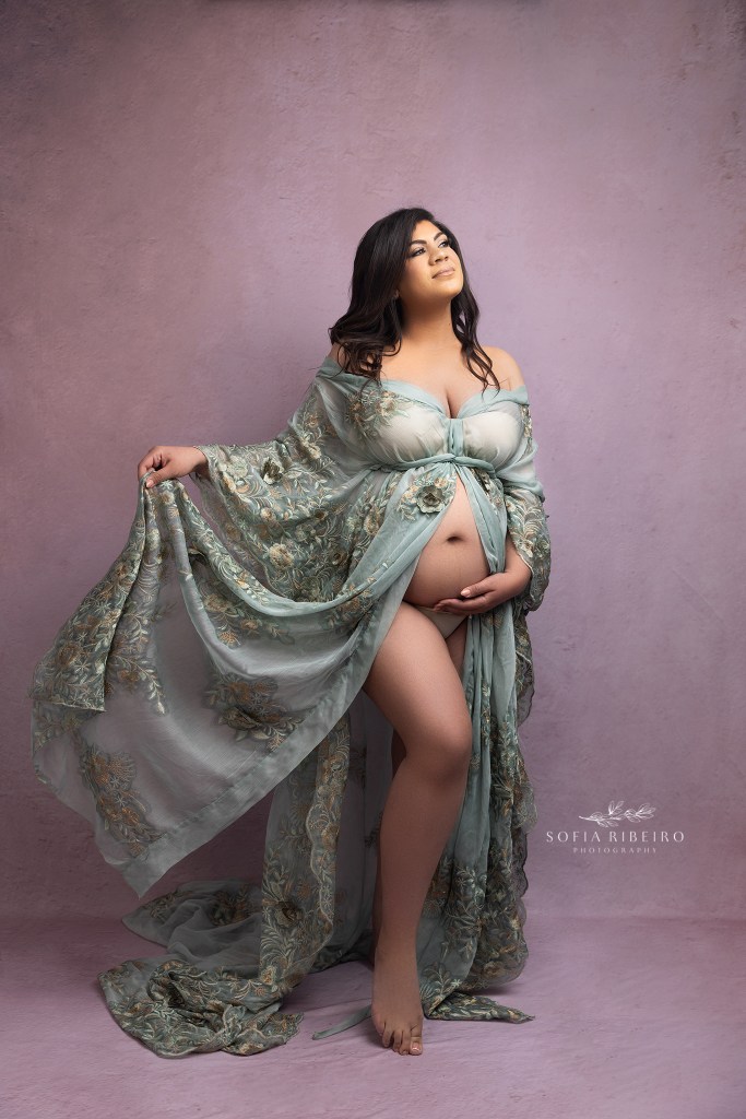 mom poses gracefully in an embroidered robe during maternity photos in ridgefield nj
