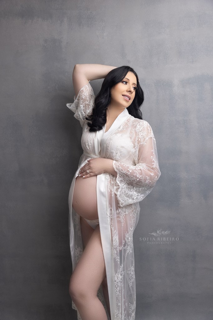 mom wears her bridal robe to showcase her baby bump during a photo session