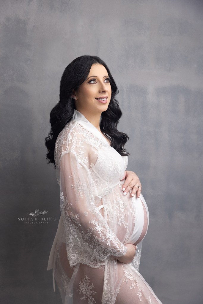 mom wears her bridal robe to showcase her baby bump during a photo session