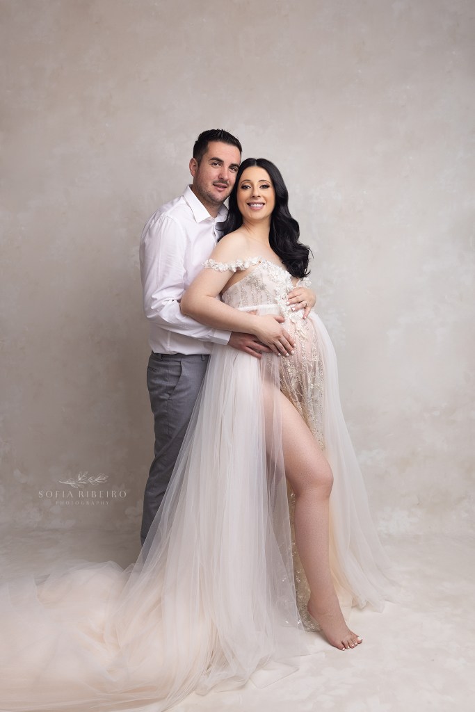 mom and dad smile to camera during a pregnancy photo session in south amboy nj