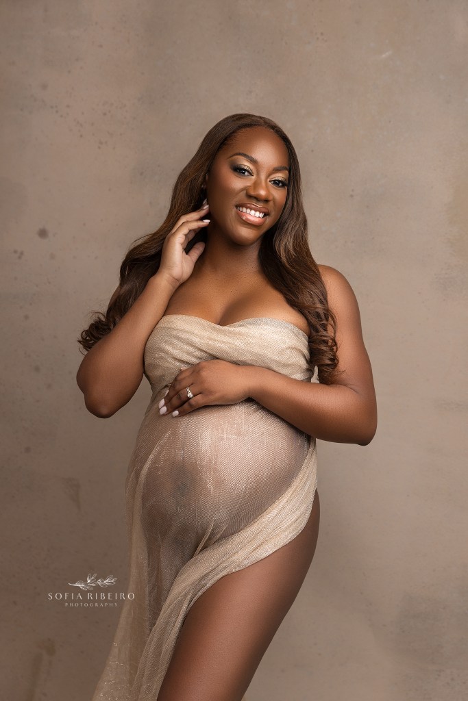 mom shimmers in a golden flecked fabric highlighting her baby bump while taking maternity photos in nj