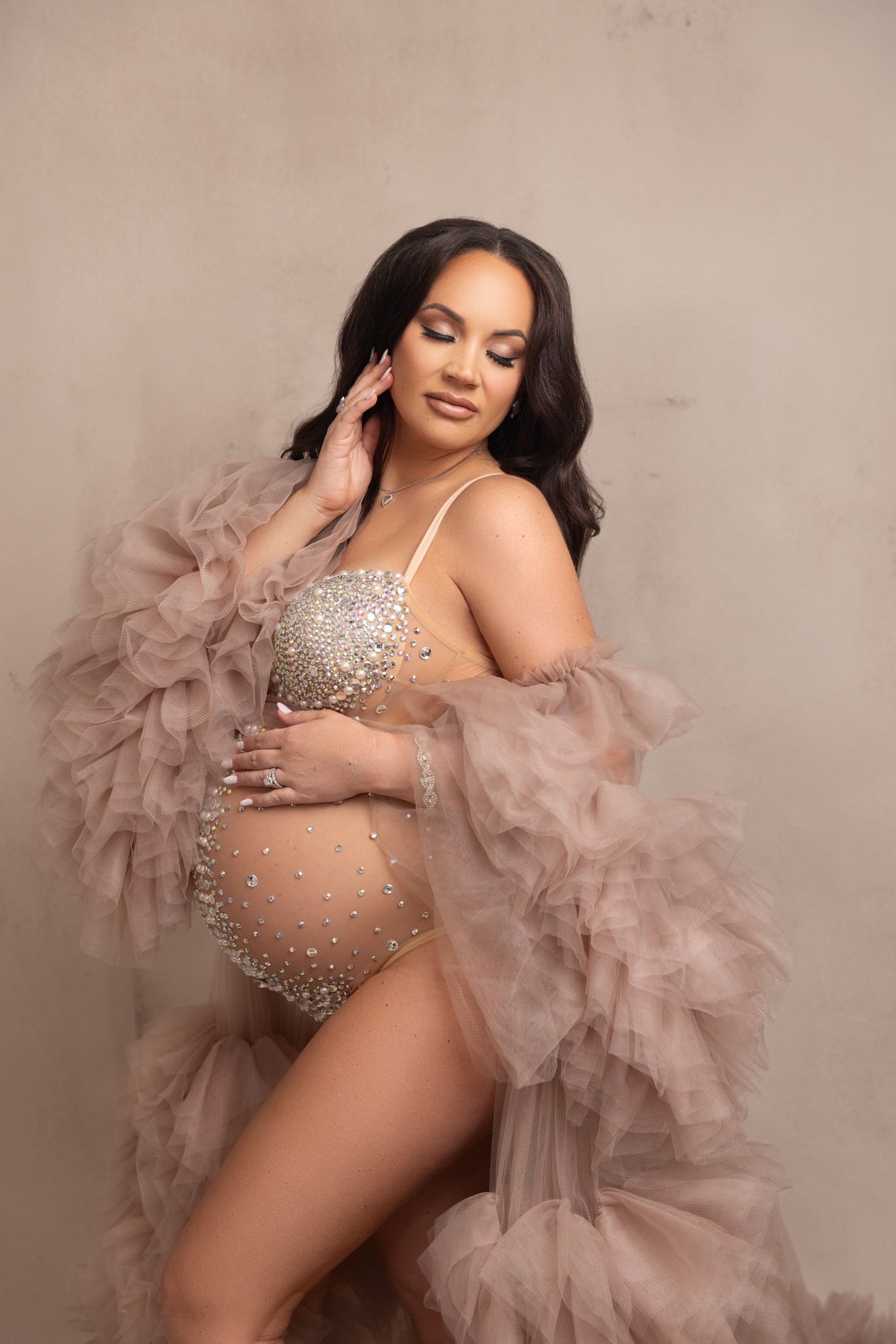 mom poses in a tulle robe and bedazzled bodysuit for a session with a nj maternity photographer