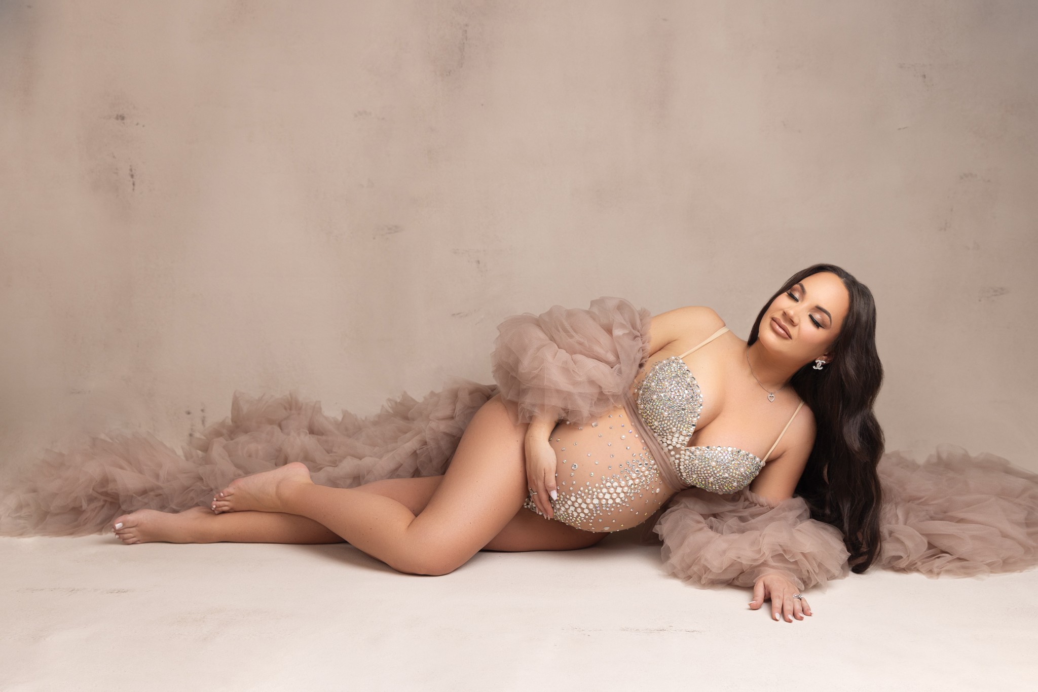 mom poses in a tulle robe and bedazzled bodysuit for a session with a nj maternity photographer