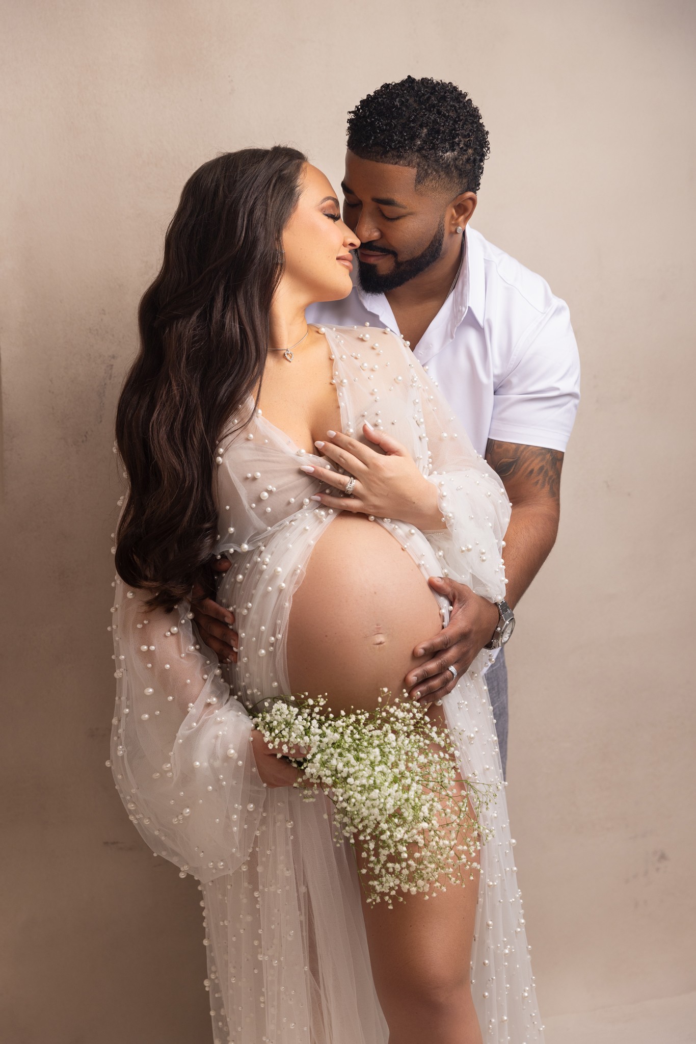 mom to be and dad hold each other lovingly while touching noses during maternity photos in nj