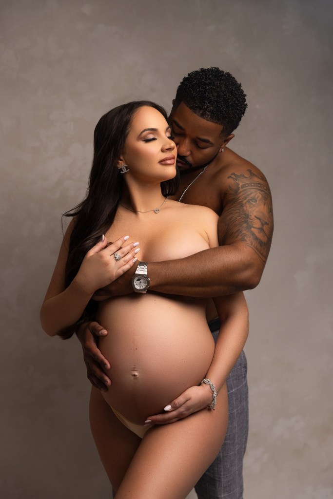 mom and dad strike a sexy pose highlighting the baby bump with an nj materntiy photographer
