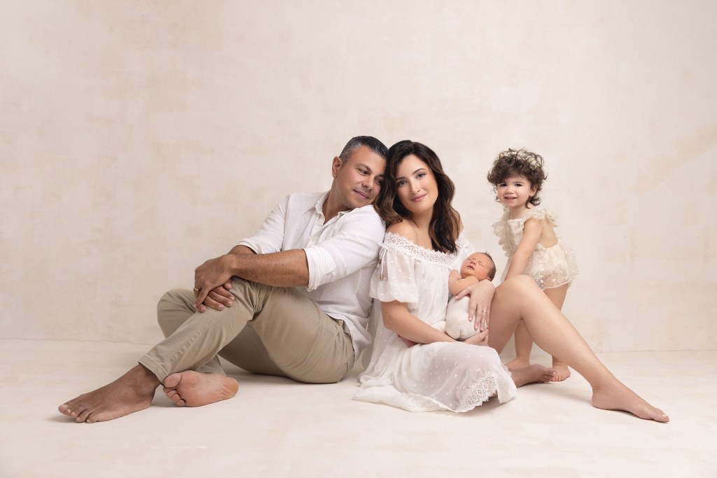 a family poses together with their new baby for photos with a nj newborn photographer