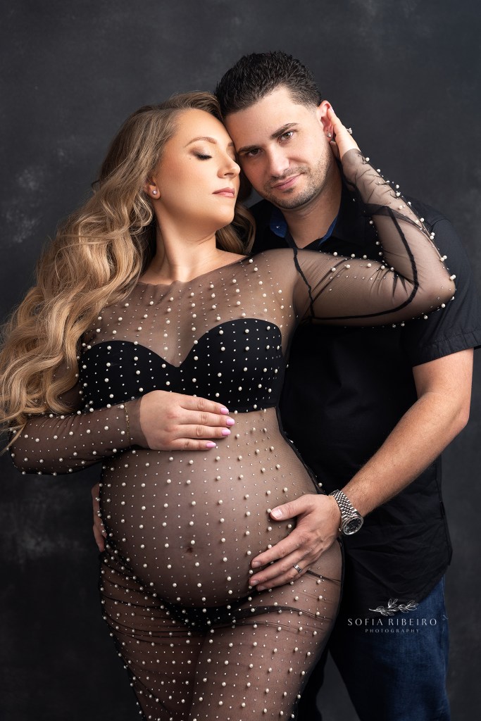 mom and dad pose together holding mom's belly for a maternity photo