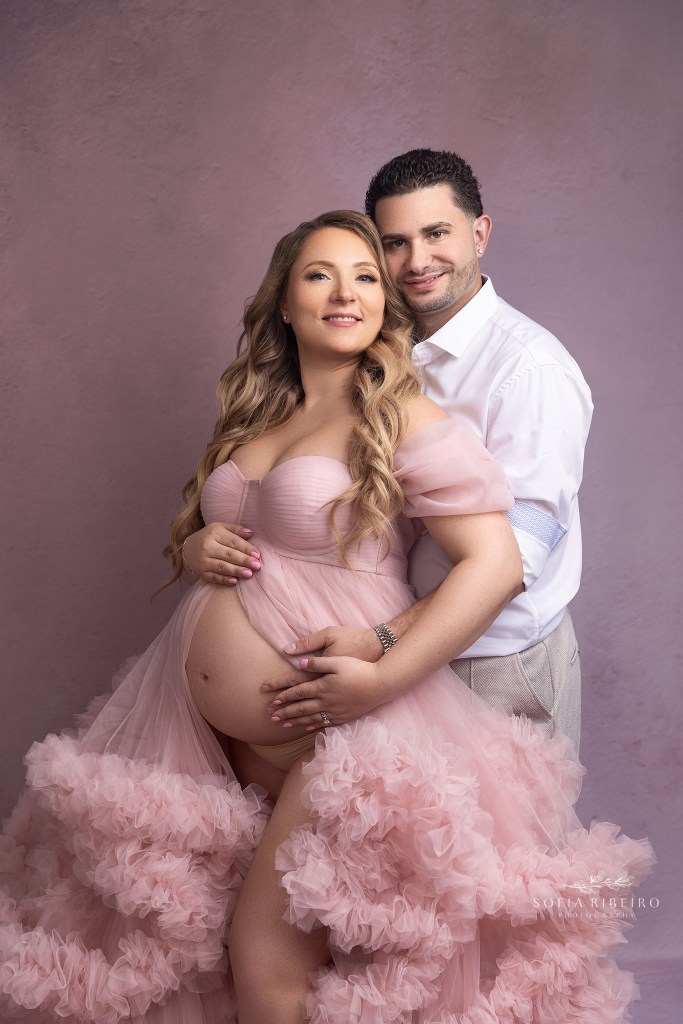 mom and dad pose proudly together showcasing mom's bump awaiting their baby girl
