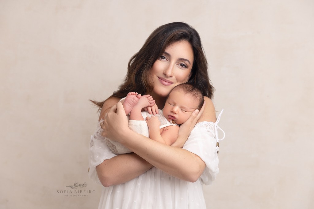 mom snuggles her tiny baby boy during a portrait session