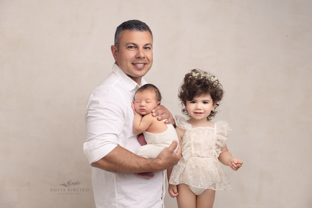 dad and his babies smile at the camera for newborn photos in red bank nj