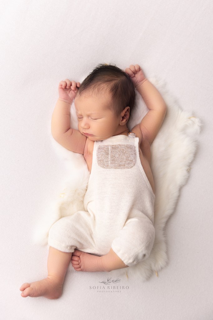 red bank nj newborn photographer captures a natural pose of a baby boy against a white backdrop