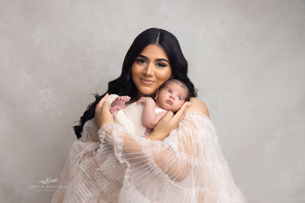 a glowing new mom cradles her baby boy, who stares wide-eyed into the camera