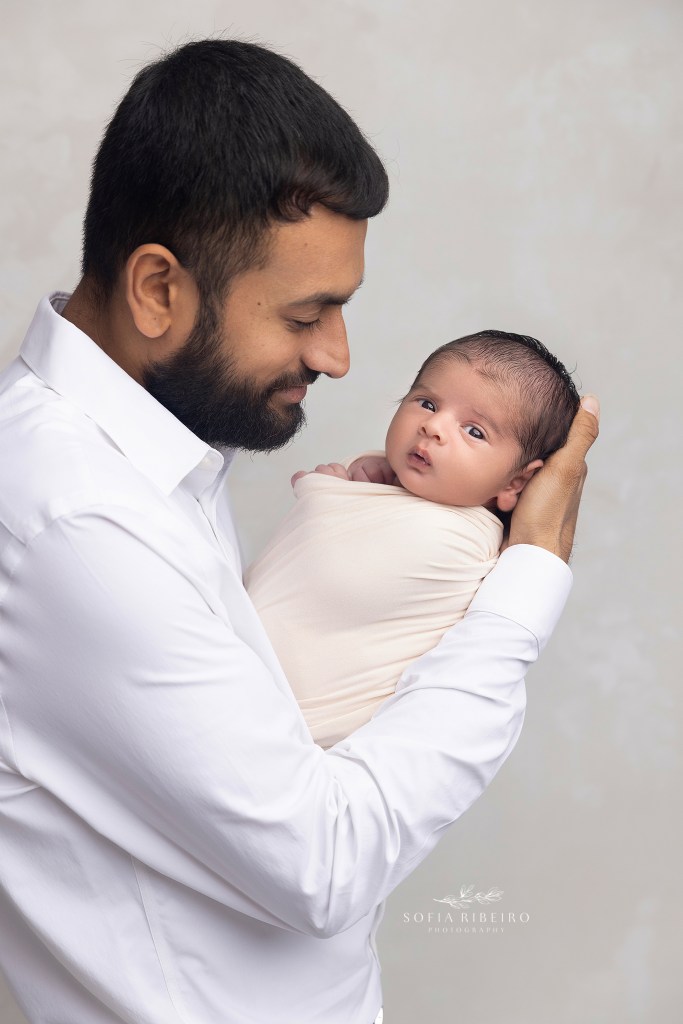dad gives his new baby boy snugglesduring a photo session in a staten island newborn photography studio