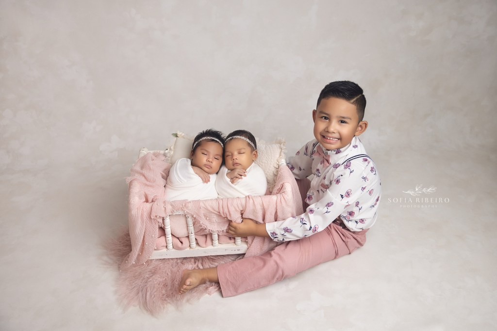 big brother snuggles his two twin baby sisters during a newborn session in Union NJ