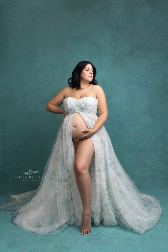 warren nj maternity photographer poses mom to be in an elegant aqua and white floral gown
