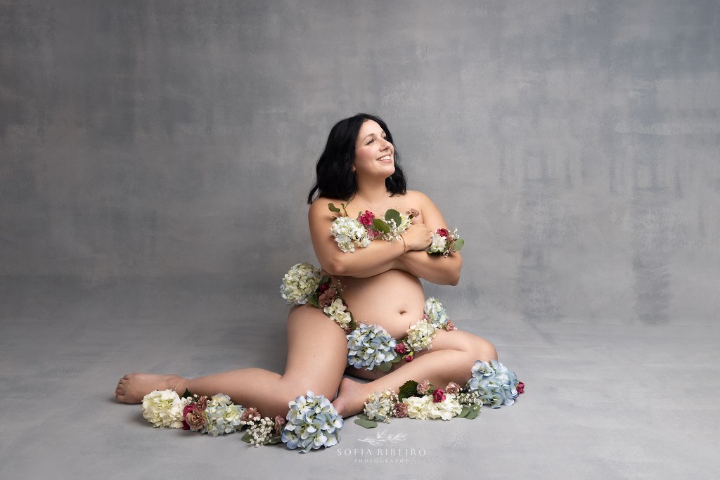 a mom poses, draped in flowers during a maternity session in warren nj