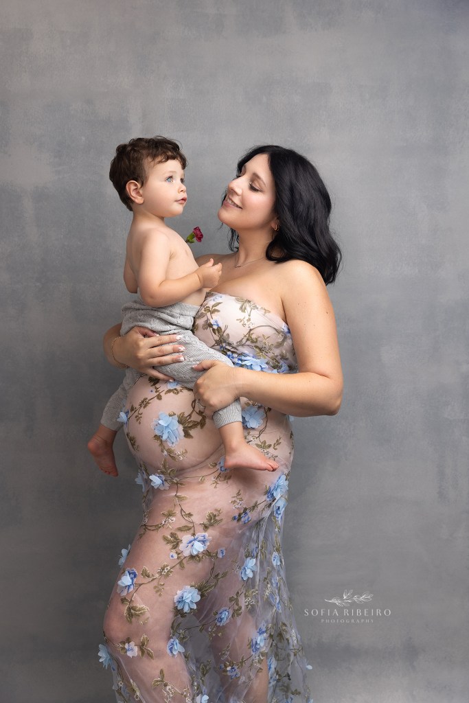 big brother offers pregnant mom a flower in this maternity portrait