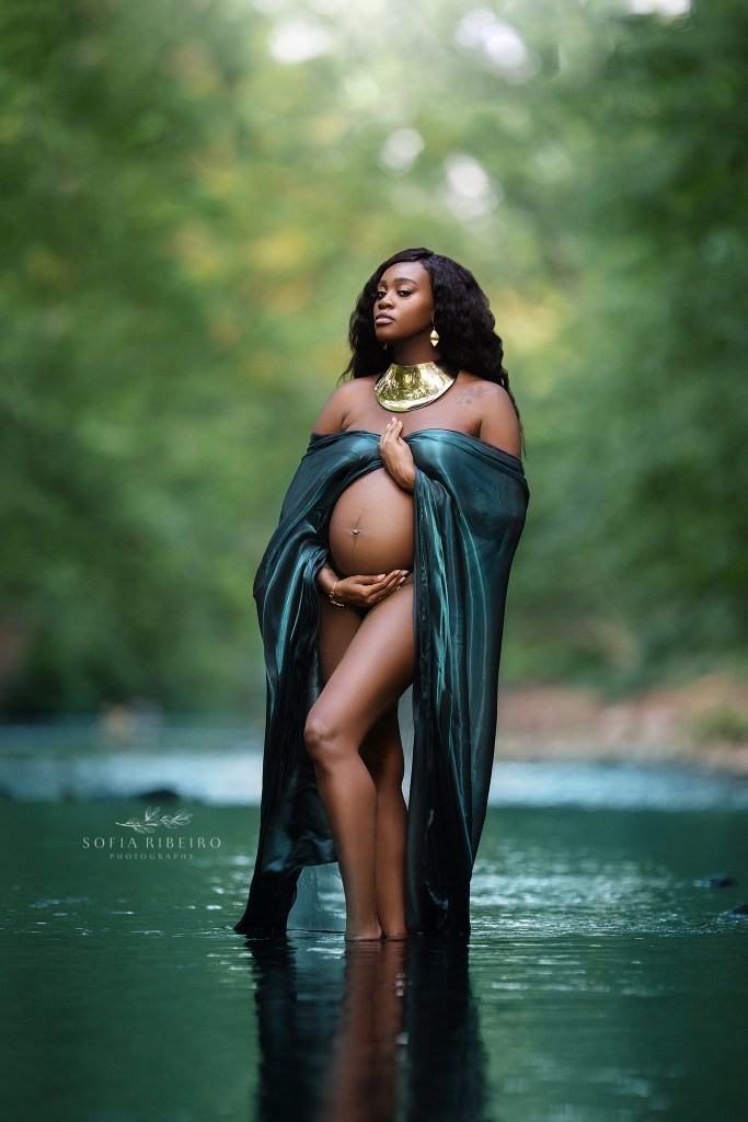 gorgeous mom to be is draped in a glowing green fabric in the magical river setting during pregnancy photos with west orange nj maternity photographer
