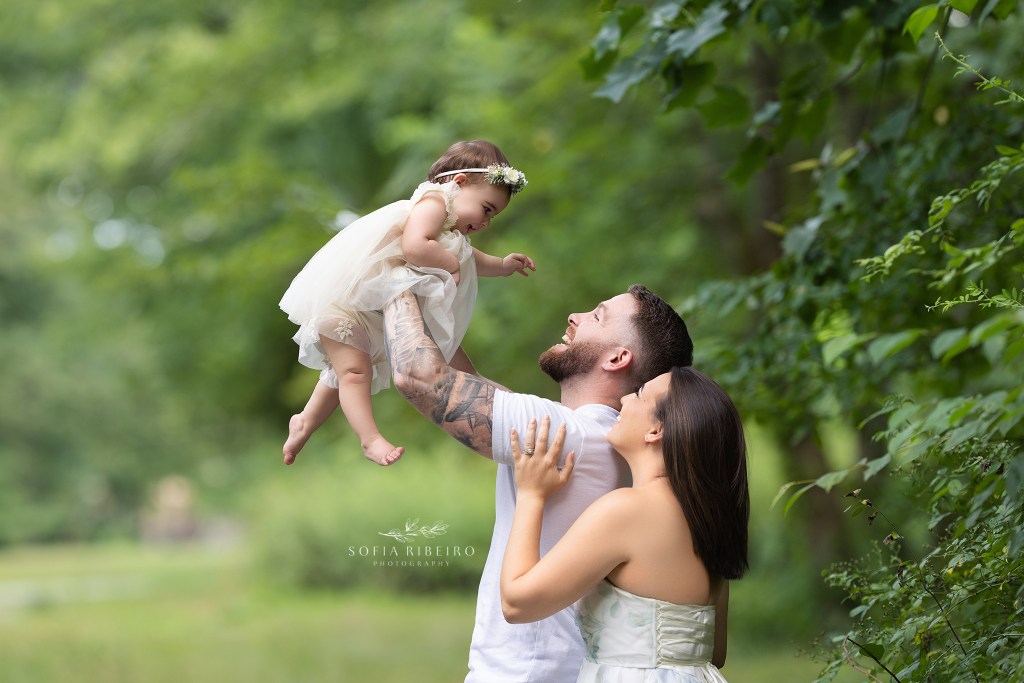 westfield nj family photographere captures an adorable family moment on camera with parents laughing with their baby girl
