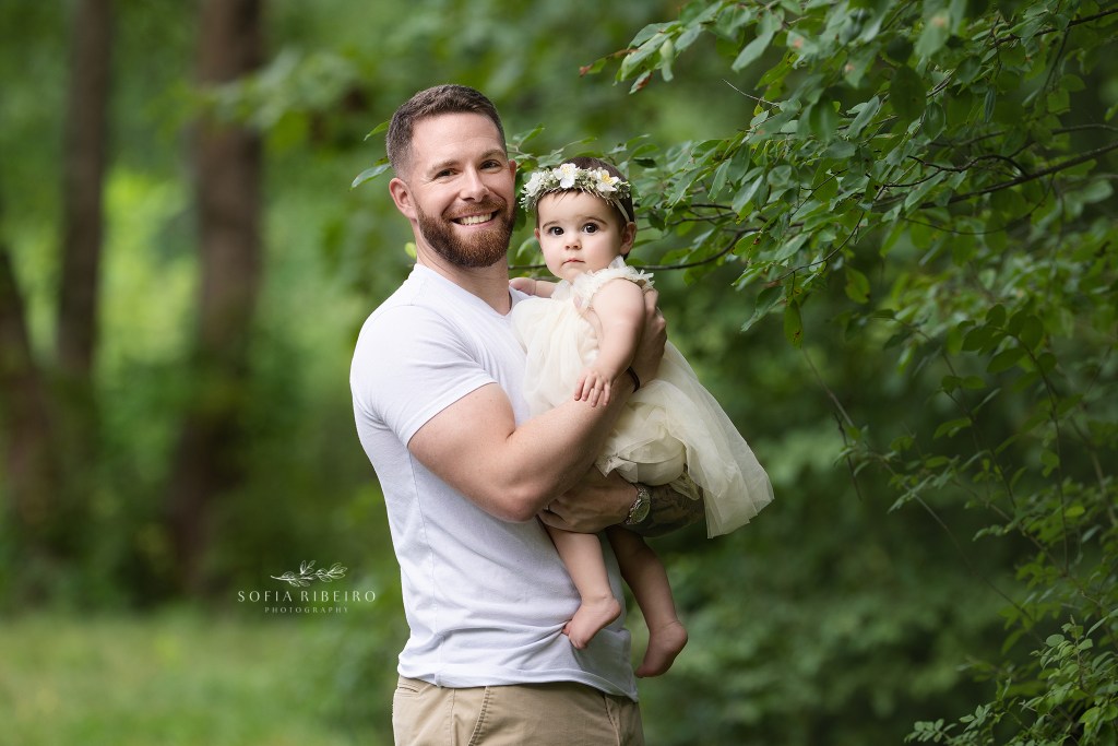 dad holds his serious baby for a sweet portrait in the greenery in westfield nj