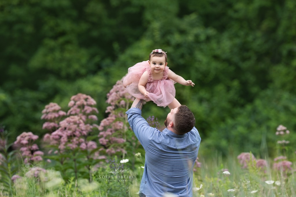 dad tosses his baby girl up in the air for some giggles in between photos