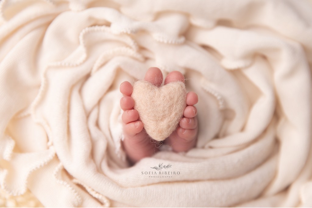 a closeup of baby feet with a heart