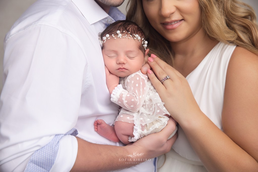 mom and dad pose proudly in neutrals for baby girl's newborn session photos